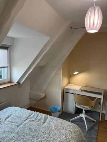 ein Schlafzimmer mit einem Schreibtisch, einem Bett und einer Lampe in der Unterkunft Chambre privée Coatodon in Guipavas