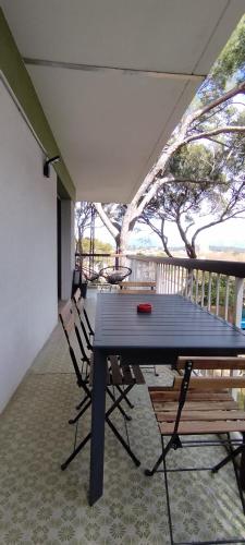 une table bleue et des chaises sur un porche avec une terrasse dans l'établissement Les Géraniums, bel appartement rénové, proche plage et commerces, à La Seyne-sur-Mer
