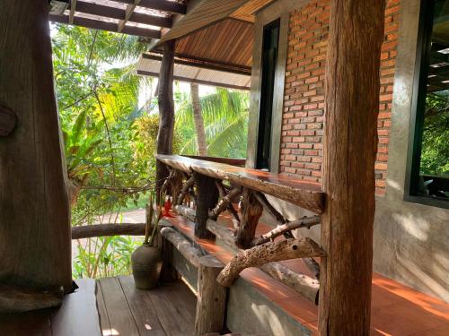 a wooden porch of a house with a window at Wooden House,Rustic charm in quiet area in Ban Khlong Chi Lat