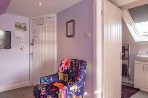 uma sala de estar com uma cadeira e um lavatório em Ard Buidhe B&B em Daliburgh