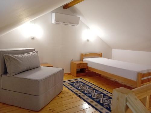a bedroom with a bed and a couch and a chair at Sherwood resort in Bihać