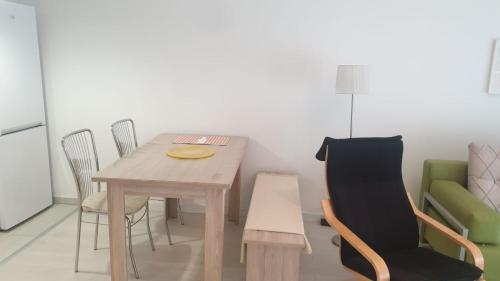 a dining room with a wooden table and chairs at White Apartments in Prishtinë