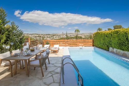 a patio with a table and chairs next to a pool at Casa Verano - Moraira in Moraira