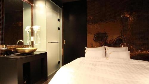 a bedroom with a white bed and a sink at Shinchon Y Hotel in Seoul