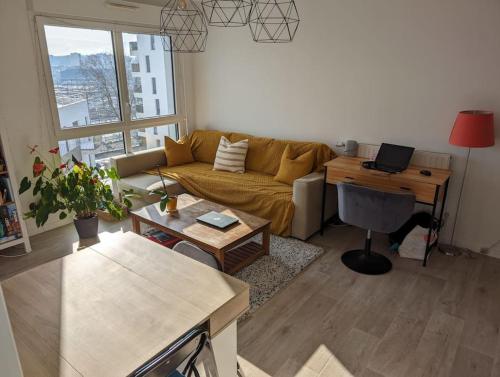 - un salon avec un canapé et un bureau avec un ordinateur portable dans l'établissement Appartement terrasse sur le canal de l’ourcq, à Bobigny