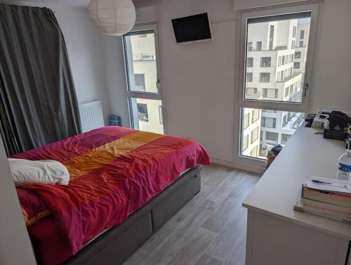 - une chambre avec un lit, un bureau et 2 fenêtres dans l'établissement Appartement terrasse sur le canal de l’ourcq, à Bobigny