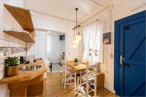 a kitchen with a table and a blue door at Ziv Boutique Apartments Town Square II in Lefkada Town