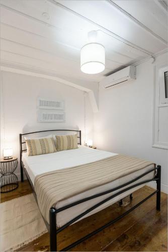 a bedroom with a large bed in a white room at Ziv Boutique Apartments Town Square II in Lefkada Town
