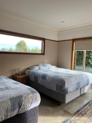 a bedroom with two beds and a window at Hadlow Sunrise Retreat in Timaru