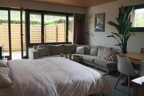 uma sala de estar com uma cama grande e um sofá em Les Sérandes em Lens