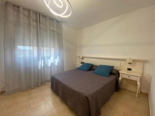 a bedroom with a bed with two blue pillows at Casetta Tommaso in Porto Ercole