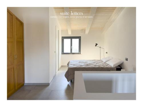 a white bedroom with a bed and a window at Casa da Zoe in Spoleto