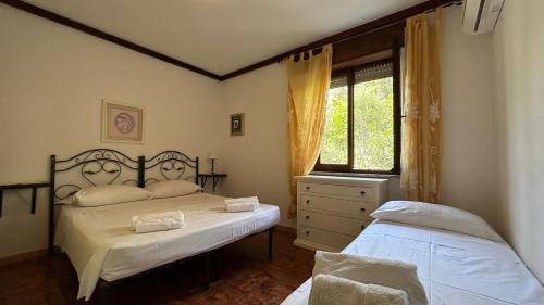 um quarto com 2 camas e uma janela em Villa Matteo San Teodoro em San Teodoro