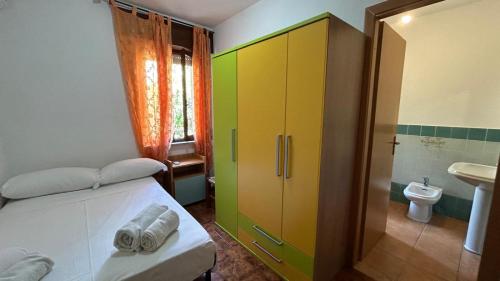 um quarto com uma cama e uma casa de banho com um lavatório em Villa Matteo San Teodoro em San Teodoro