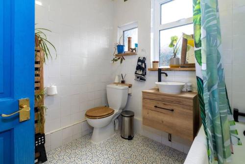 a bathroom with a toilet and a sink and a window at Boho Hideaway in Lea Bridge in London