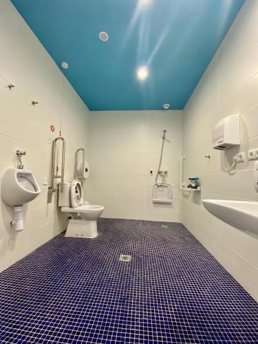 a bathroom with a blue ceiling and a toilet and sink at We Street Hostel - Albergue in El Arenal