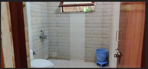 baño con aseo y cubo de basura azul en Hotel Comfort Regency, en Bharatpur