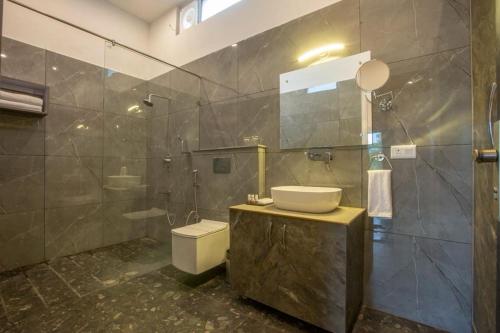 La salle de bains est pourvue d'un lavabo, de toilettes et d'une douche. dans l'établissement Countryard Resort By EWD Hotels, à Nainital