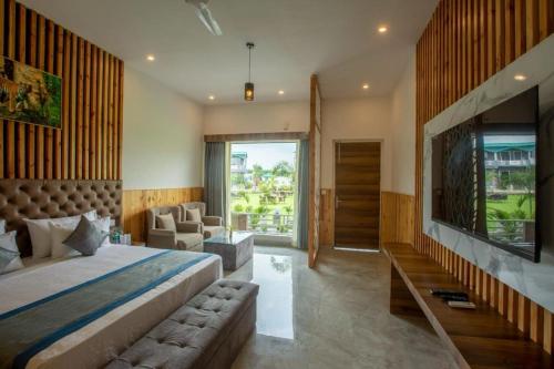 - une chambre avec un grand lit et une grande fenêtre dans l'établissement Countryard Resort By EWD Hotels, à Nainital