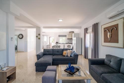 una sala de estar con 2 sofás azules y una mesa. en Casita Los Garranchos, en Córdoba