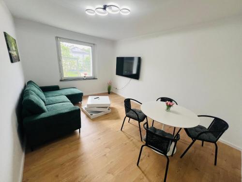 a living room with a green couch and a table at Entire House l 12 Beds l 8 Room l Floor-Heating l WiFi in Lippstadt