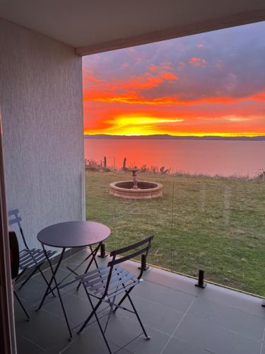 a view of a sunset from a patio with a table and chairs at VistaMirage - Mystic Ridge Estate in Bywong