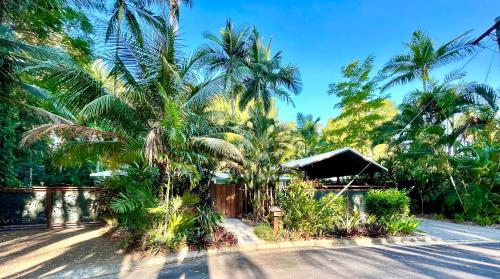 a house with palm trees on the side of a road at Karinya in Clifton Beach