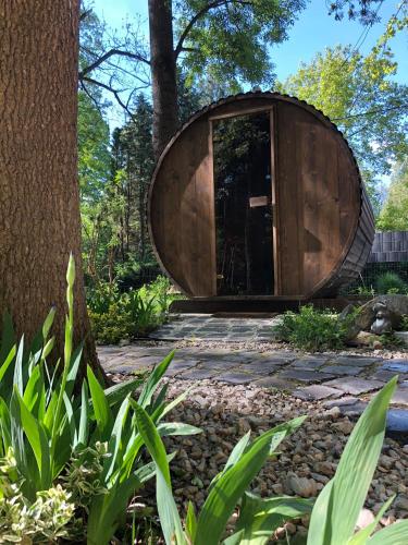 a wooden circle house in the middle of a garden at Mókus Vendégház in Doboz