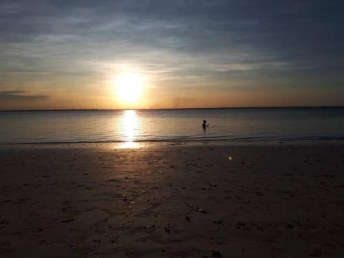 a person walking in the water on the beach at Karibu Paradaizi in Michamvi