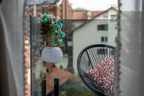 a black chair sitting on a balcony with a plant at Dorin Kutak, klimatizovan, garažno mesto in Zlatibor