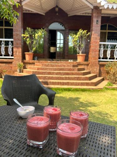 a table with four glasses of pink drinks on it at Sai Leela Bungalow - Villa with Private Pool in Mahabaleshwar