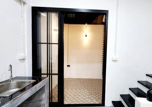 a bathroom with a glass door and a sink at LS 1 Lasalle House,bts,Suvarnabhumi ,mega bangna in Bangkok