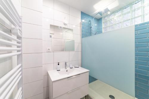 une salle de bain blanche avec un lavabo et un miroir dans l'établissement Appartement familial, lumineux, à Toulon