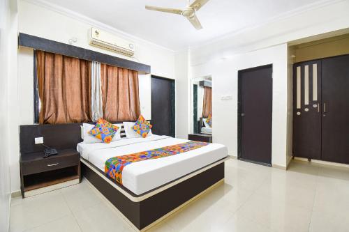a bedroom with a large bed in a room at FabHotel Yashraj Inn in Vagholi