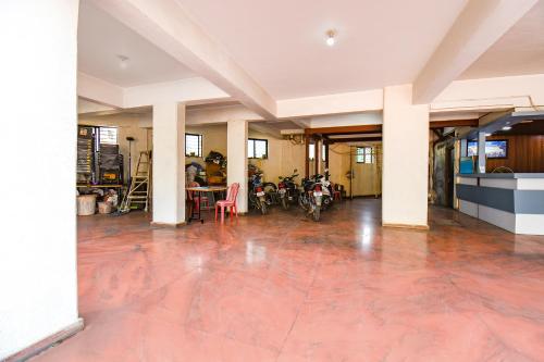 an empty room with red tile floors and white columns at FabExpress Yashraj Inn - BJS College in Wagholi