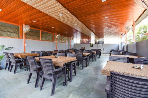 a dining room with tables and chairs in a restaurant at FabExpress Yashraj Inn - BJS College in Wagholi