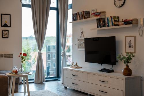 a living room with a flat screen tv on a dresser at Dorin Kutak, klimatizovan, garažno mesto in Zlatibor