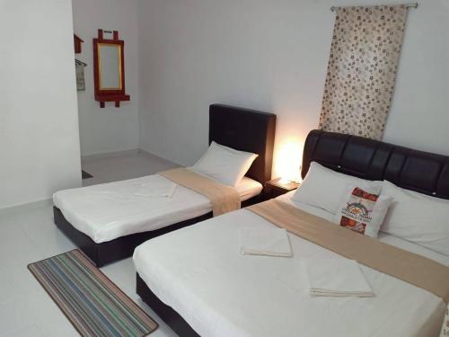 una habitación con dos camas y un espejo en Chenang Indah Chalets, en Pantai Cenang