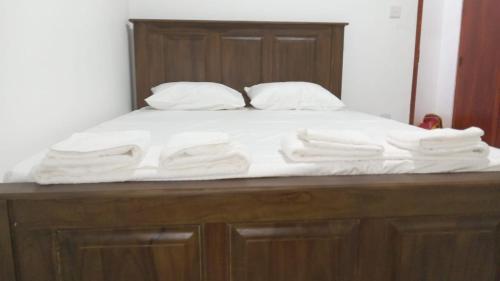 un letto con asciugamani bianchi sopra di Oasis Villa a Negombo