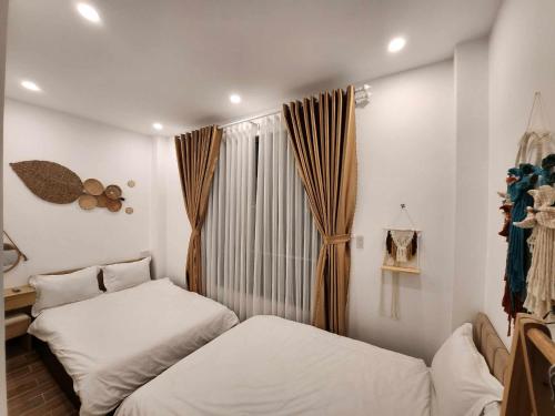 a bedroom with two beds and a window at Khách sạn Hoàng Khôi in Da Lat