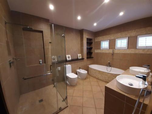 uma casa de banho com 2 lavatórios, um chuveiro e 2 WC em Prince's Grant Family Holiday paradise em New Guelderland