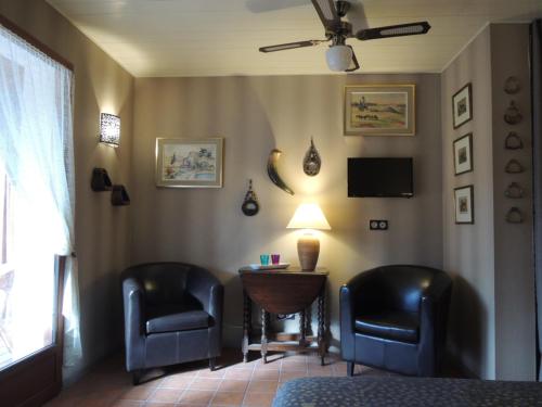 a room with two chairs and a table and a lamp at Via Bahia - Maison d'hôtes in Biscarrosse
