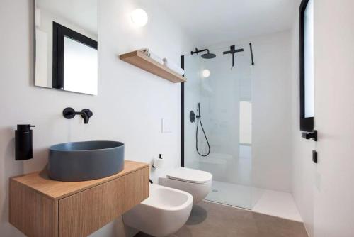 a bathroom with a sink and a toilet and a shower at Villa Greghe-Lusso con piscina in Lazise