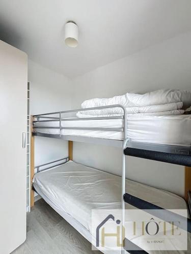 une chambre avec deux lits superposés dans une pièce dans l'établissement Échappée Belle, Confort, Plage et Parking, à Bray-Dunes