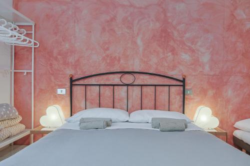 a bedroom with a large bed with a red wall at B&B Cristina e Stefano in Pisa