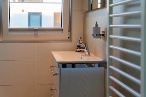 Un baño pequeño con lavabo y ventana. en Hausboot Arielle, en Ribnitz-Damgarten