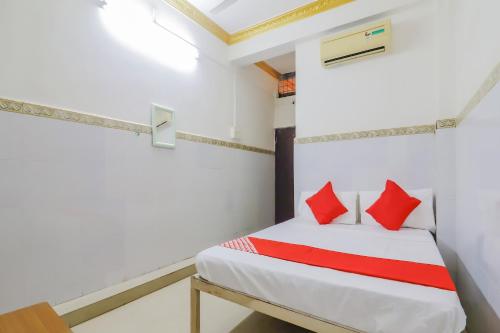 Un dormitorio con una cama con almohadas rojas. en OYO 79037 Metro Lodge en Hyderabad