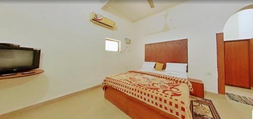 1 dormitorio con 1 cama y TV en Hotel Comfort Regency, en Bharatpur