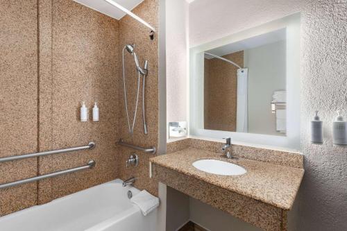 a bathroom with a sink and a tub and a mirror at Days Inn by Wyndham Chattanooga Lookout Mountain West in Chattanooga