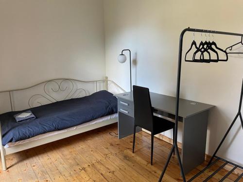 a bedroom with a bed and a desk and a desk and a chair at Sisters Beach Apartments in Liepāja